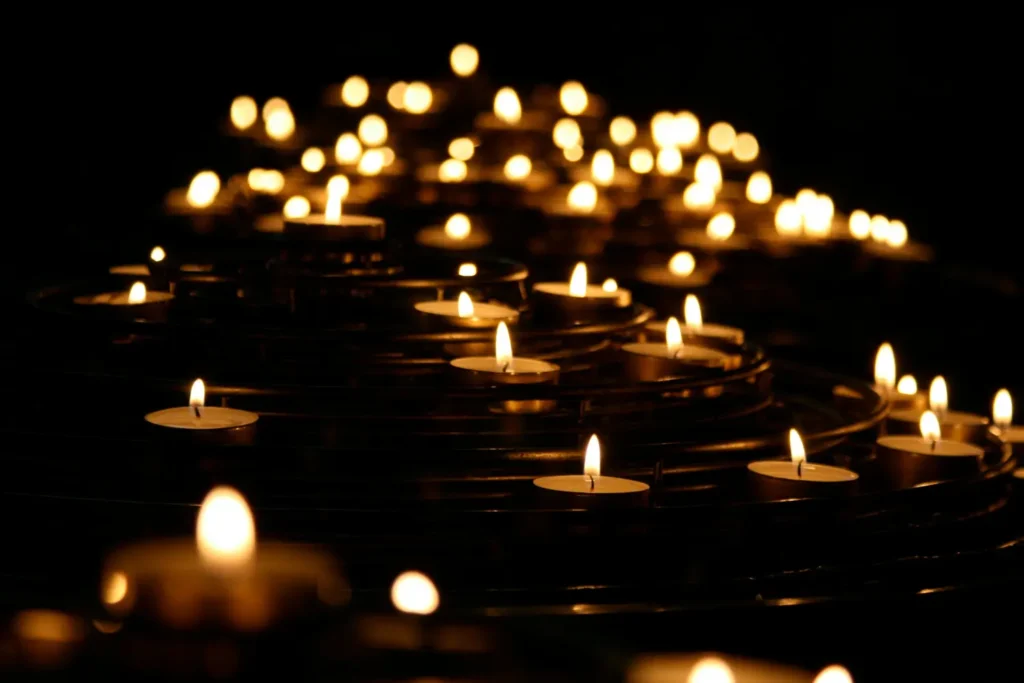 a group of lit candles in the dark of night